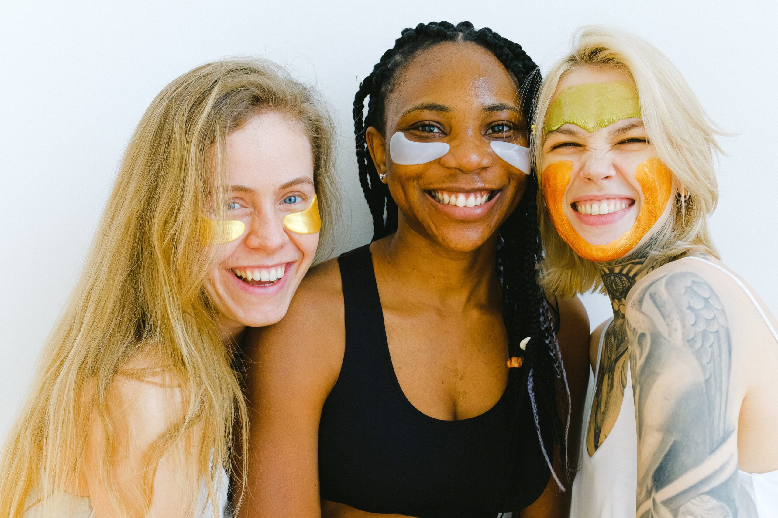 groupe de femmes en train de sourire tout en faisant un soin anti-cernes